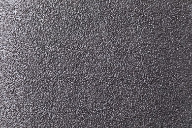 Photo of Texture of coarse sandpaper as background, top view