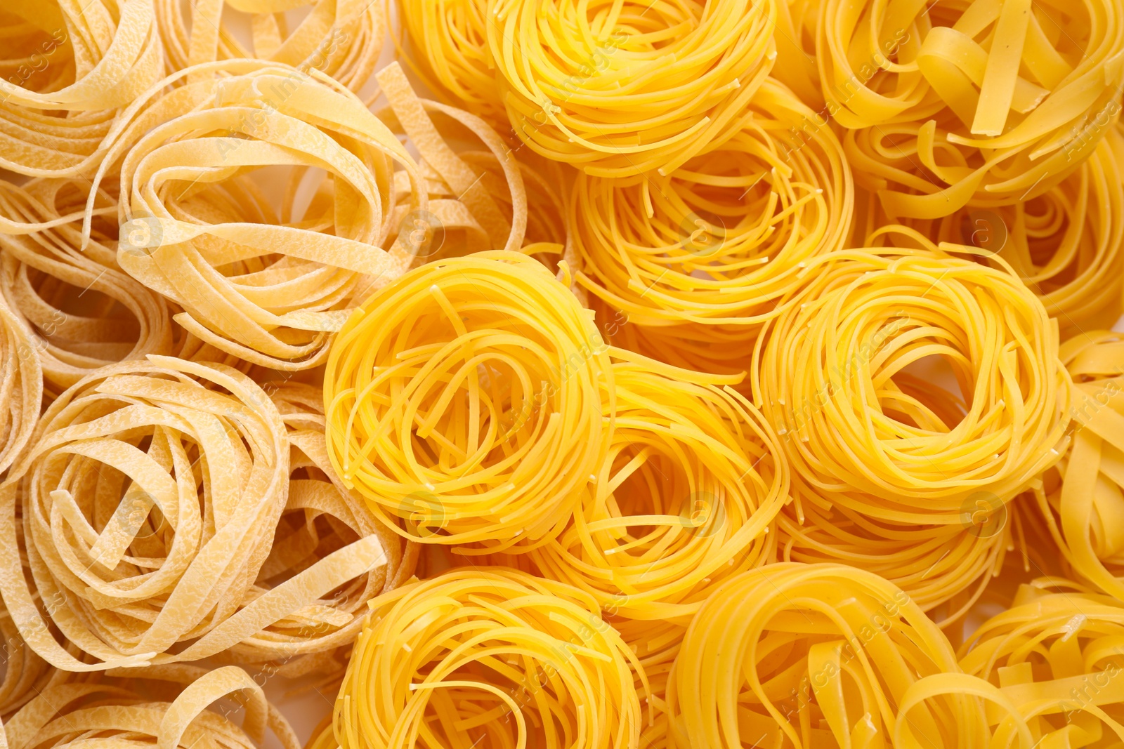 Photo of Different types of pasta as background, top view