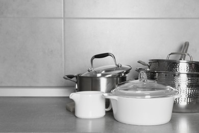 Photo of Different cookware on grey countertop. Space for text