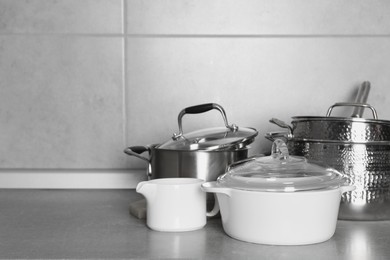 Different cookware on grey countertop. Space for text