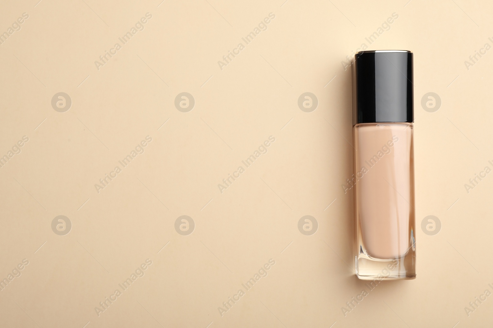 Photo of Bottle of skin foundation and space for text on color background, top view