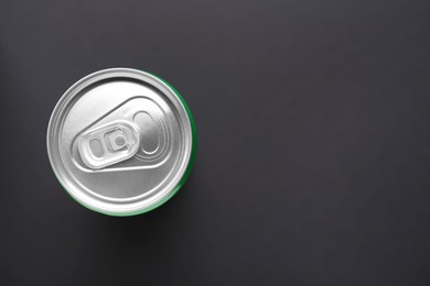 Photo of Energy drink in can on black background, top view. Space for text