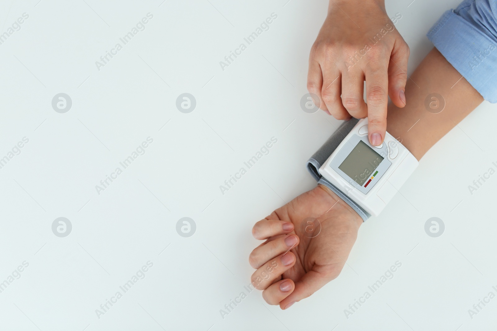 Photo of Woman checking blood pressure on white background, top view with space for text. Cardiology concept