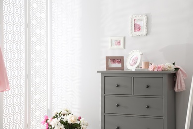 Photo of Grey chest of drawers in stylish room interior. Space for text