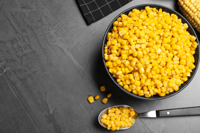 Photo of Delicious canned corn in bowl on grey table, flat lay. Space for text