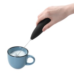 Woman whisking milk in cup with mini mixer (frother wand) isolated on white