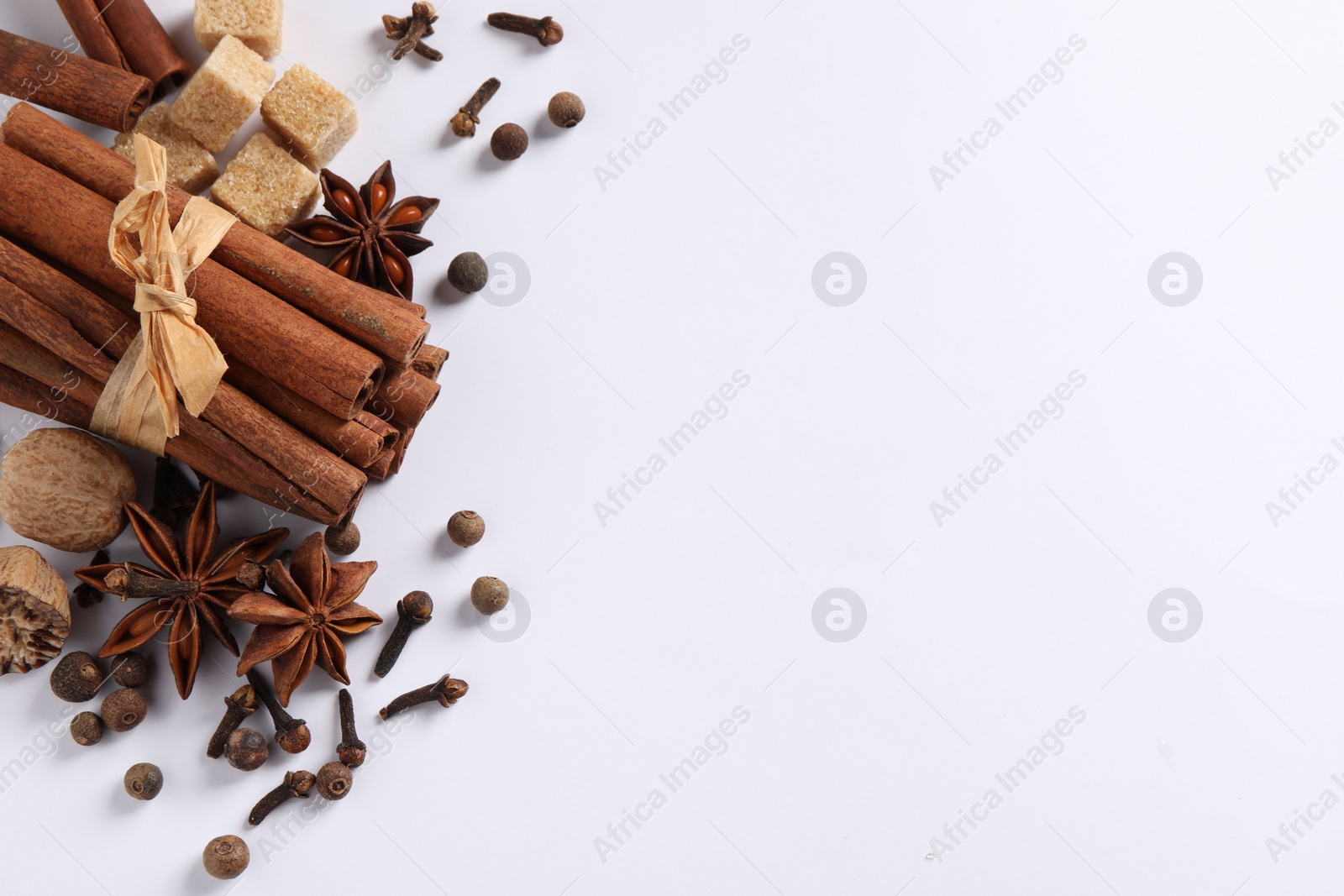 Photo of Different spices and nuts on white table, flat lay. Space for text