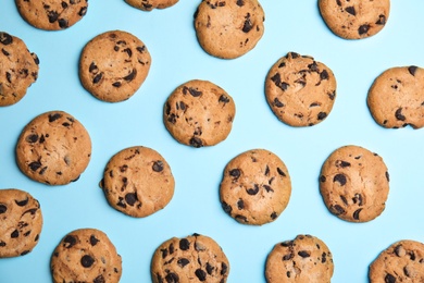 Delicious chocolate chip cookies on color background, flat lay