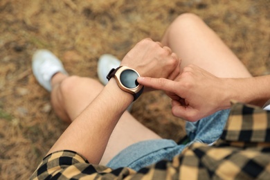 Man using stylish smart watch outdoors, closeup