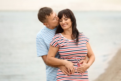 Photo of Happy mature couple spending time together on sea beach