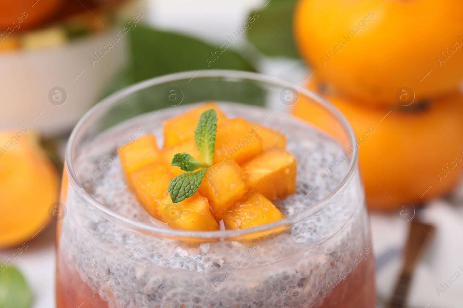 Photo of Delicious dessert with persimmon and chia seeds, closeup