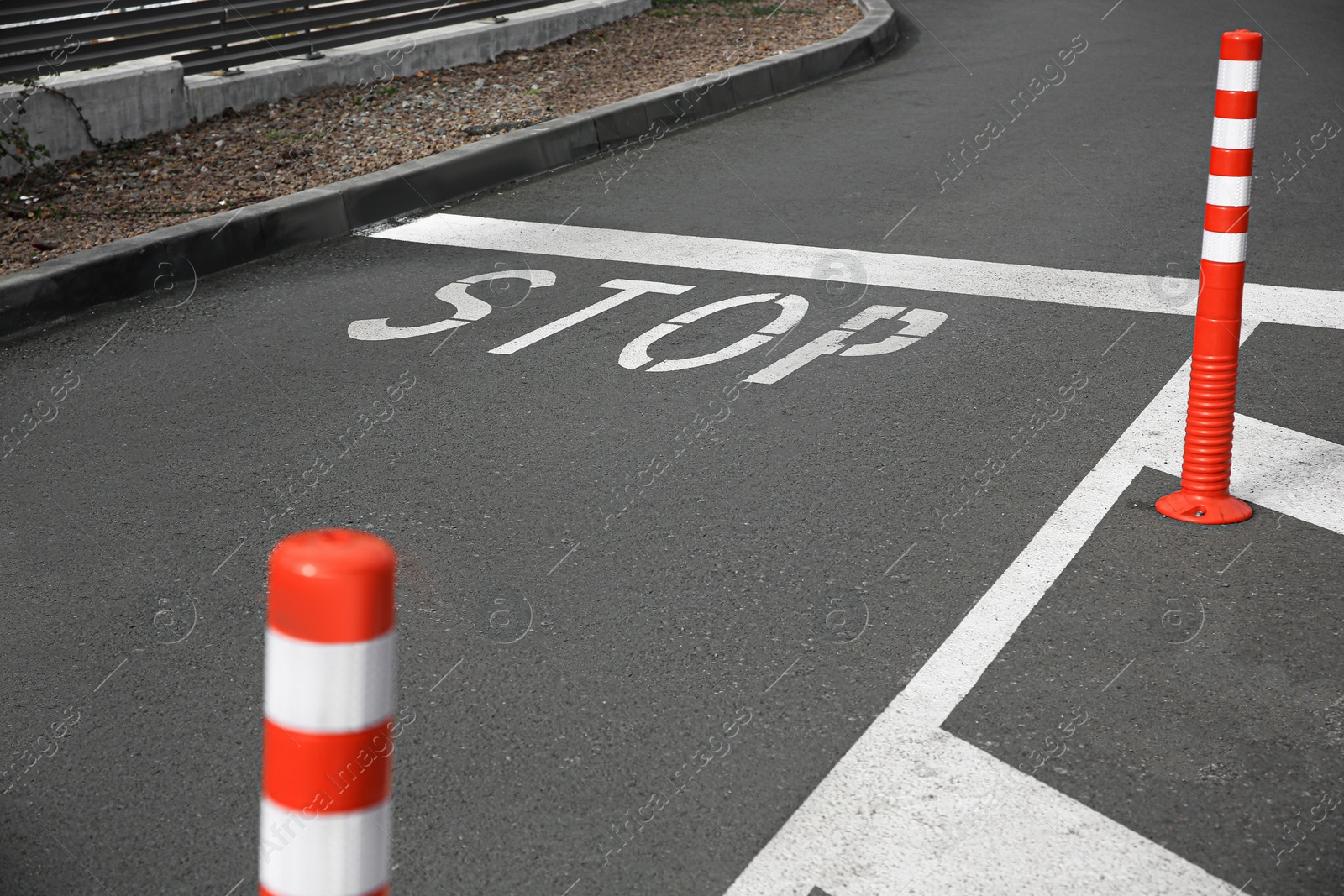Photo of White painted stop marking on asphalt outdoors