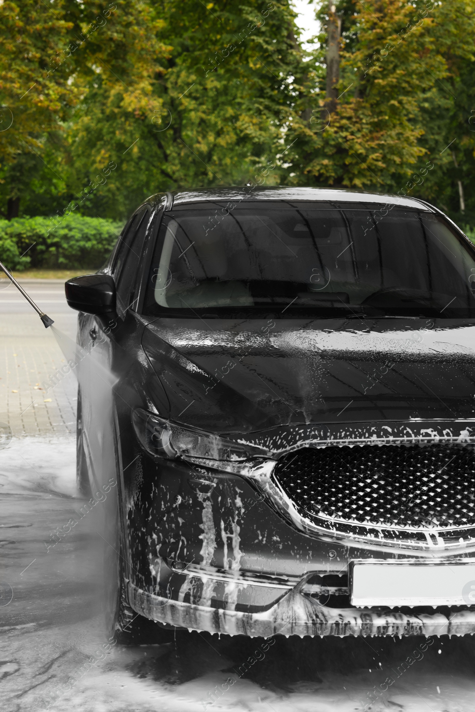 Photo of Washing auto with high pressure water jet at outdoor car wash