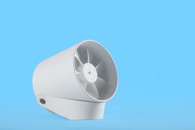 Photo of Modern electric fan on light blue background