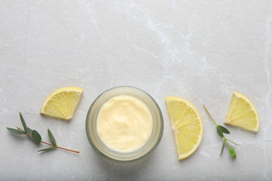 Photo of Jar of organic cream and lemon slices on light marble table, flat lay. Space for text