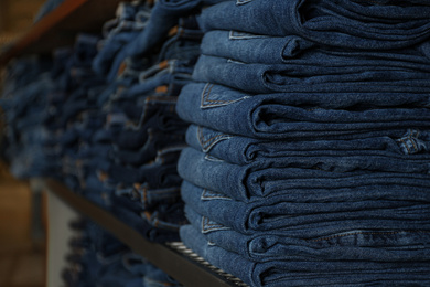 Collection of stylish jeans on shelf in shop
