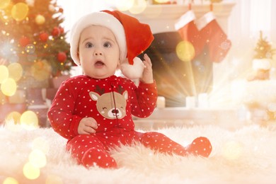 Baby in Santa hat and bright Christmas pajamas on floor at home. Magical festive atmosphere