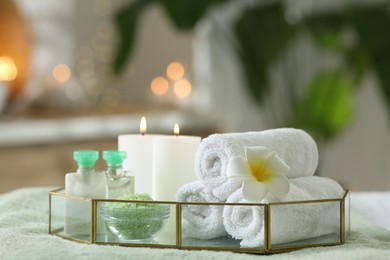 Photo of Composition with different spa products and burning candles on table indoors
