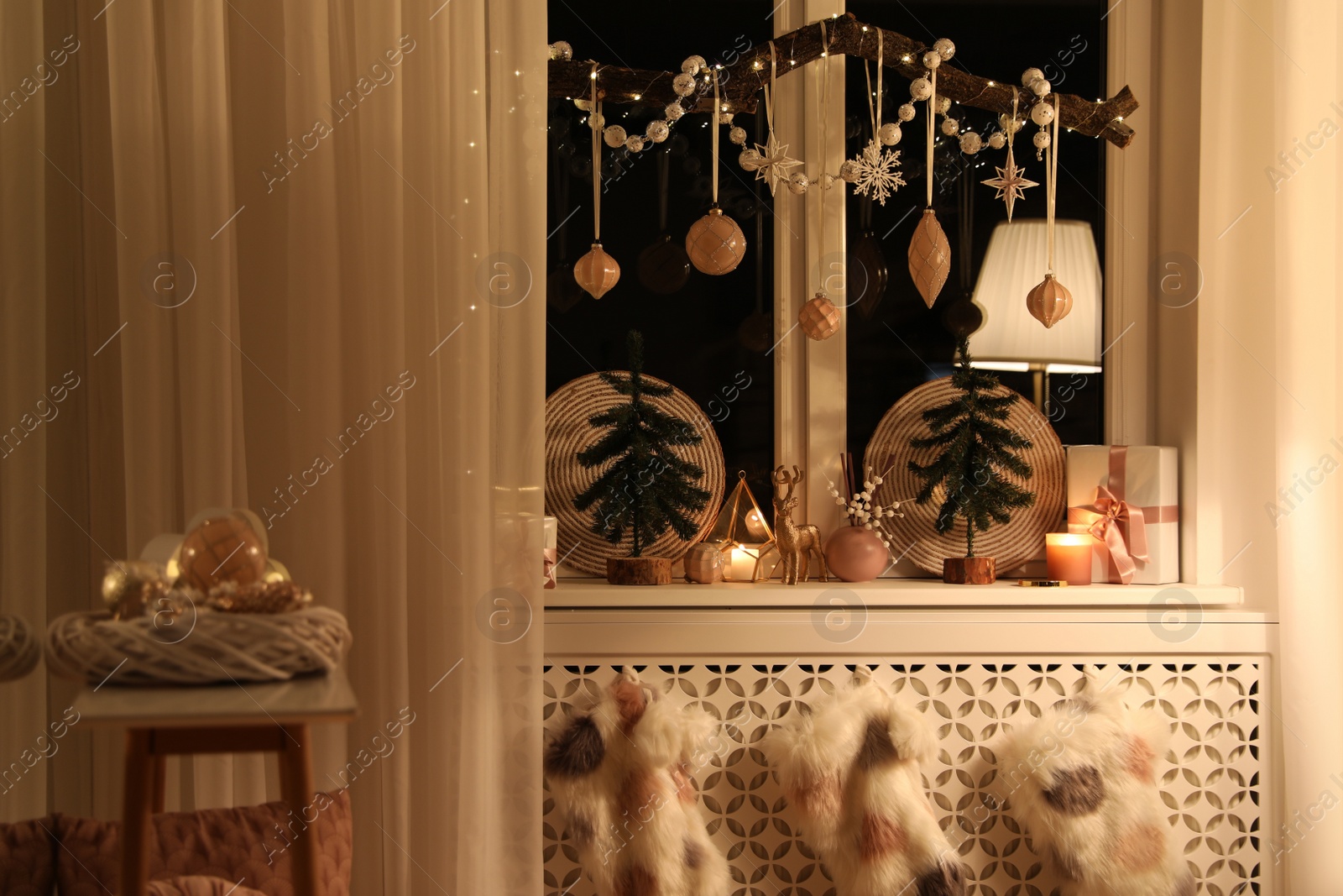 Photo of Beautiful room interior with small fir trees in evening. Christmas decor