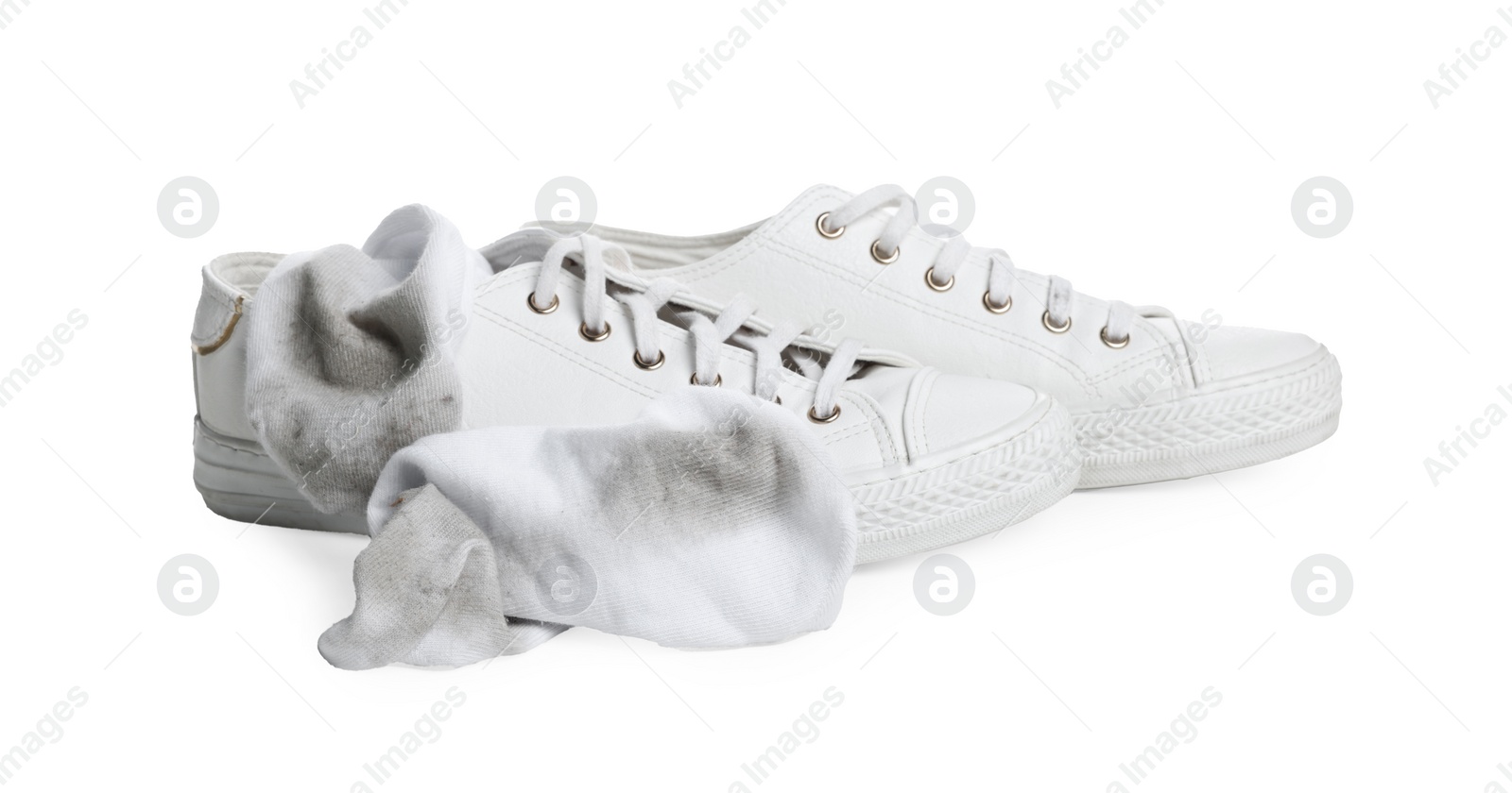 Photo of Dirty socks and sneakers on white background