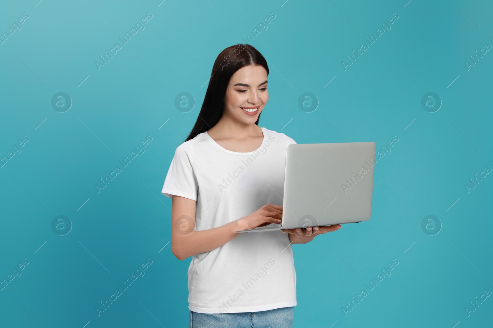 Photo of Young woman with modern laptop on light blue background