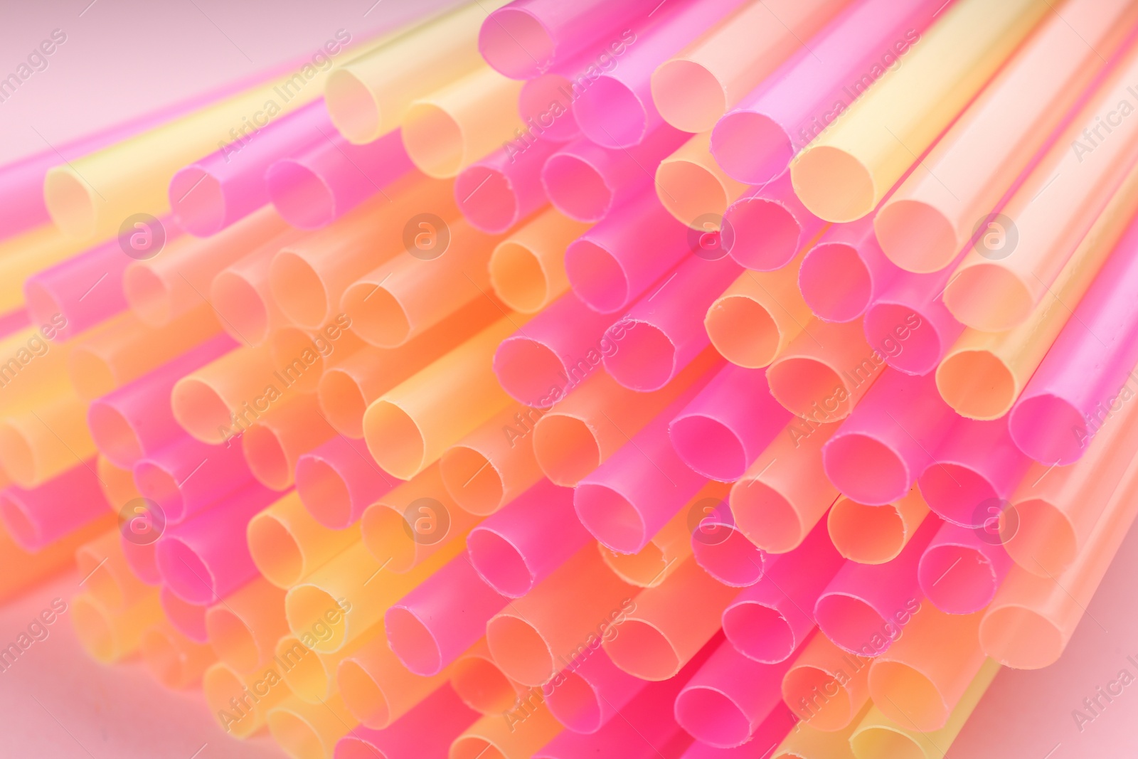 Photo of Heap of colorful plastic straws for drinks, closeup