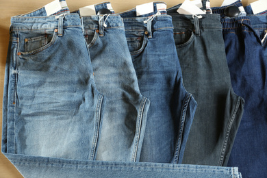 Photo of Modern blue jeans on display in shop, top view