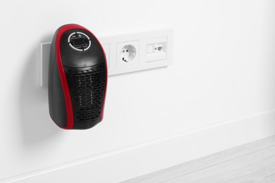 Photo of Portable electric heater on white wall indoors. Space for text