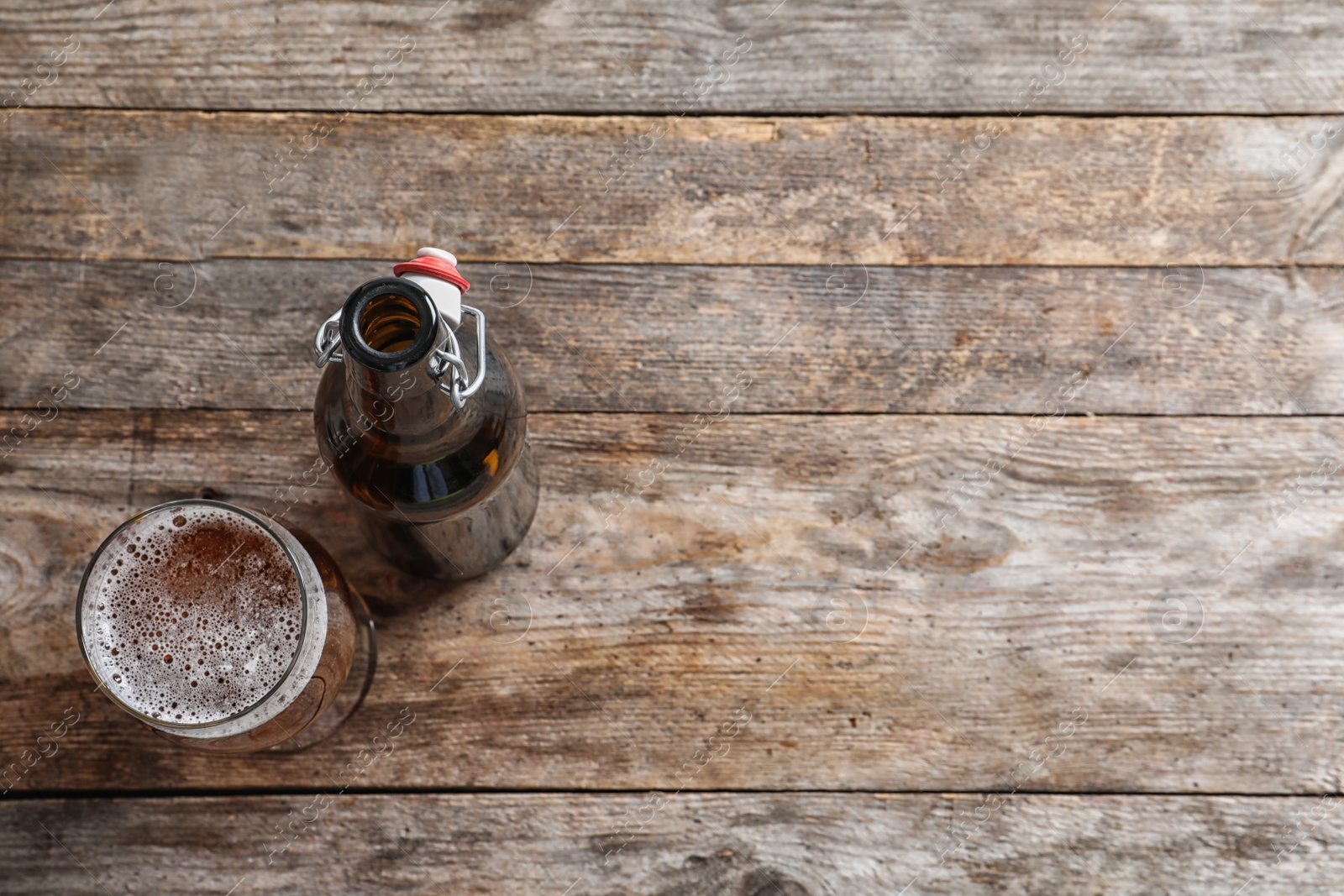 Photo of Bottle and glass with tasty cold beer on wooden background