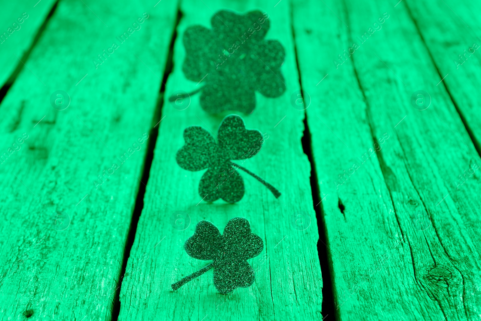 Image of St. Patrick's day. Decorative clover leaves on green wooden background