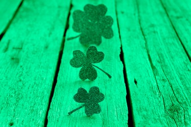 Image of St. Patrick's day. Decorative clover leaves on green wooden background