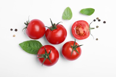 Fresh green basil leaves, spices with cut and whole tomatoes on white background, top view