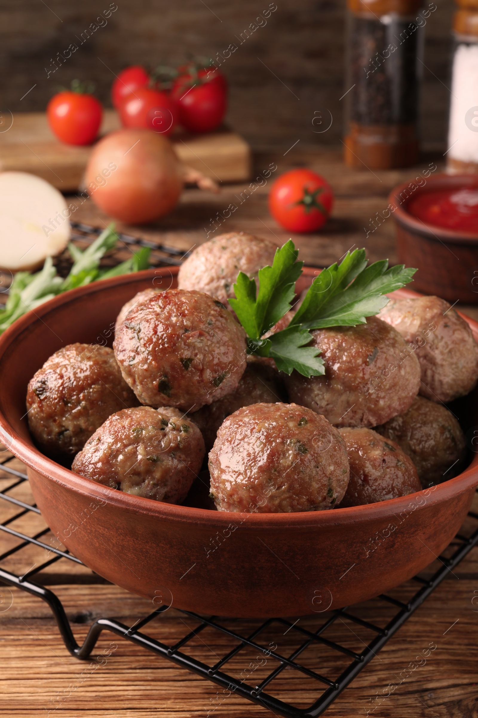 Photo of Tasty cooked meatballs with parsley on wooden table