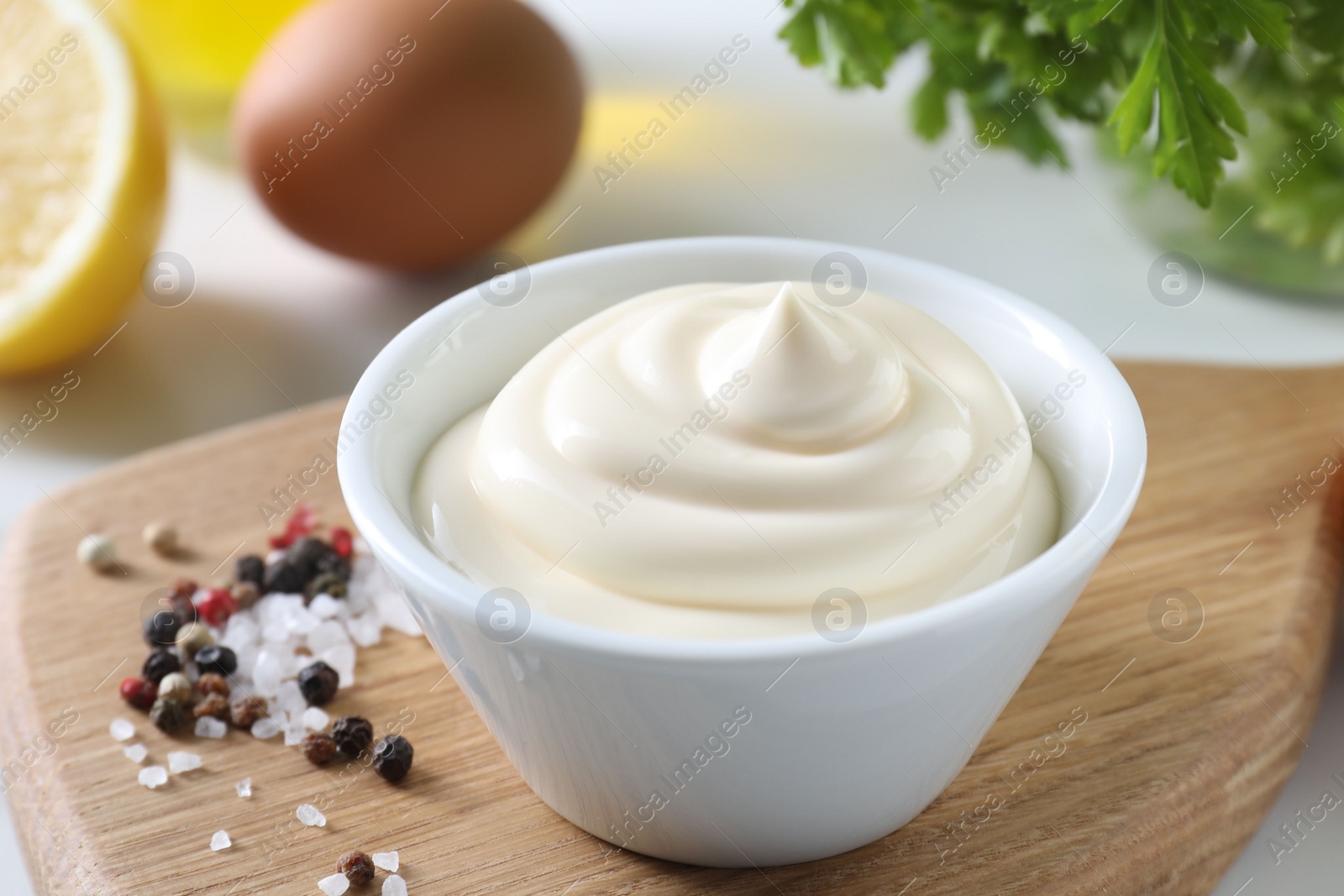 Photo of Tasty mayonnaise sauce in bowl and spices on table, closeup