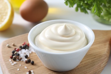 Photo of Tasty mayonnaise sauce in bowl and spices on table, closeup