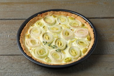 Tasty leek pie with thyme on wooden table