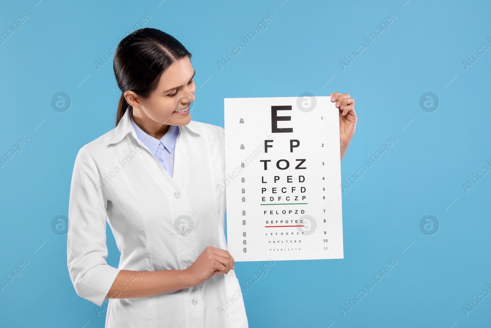 Photo of Ophthalmologist with vision test chart on light blue background