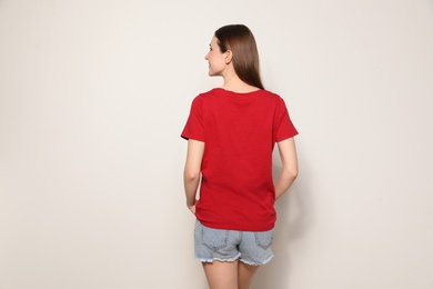 Photo of Young woman in t-shirt on light background. Mock up for design