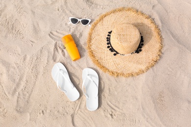 Photo of Set of different stylish beach accessories on sand, flat lay
