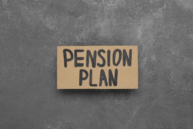 Photo of Card with words Pension Plan on grey table, top view