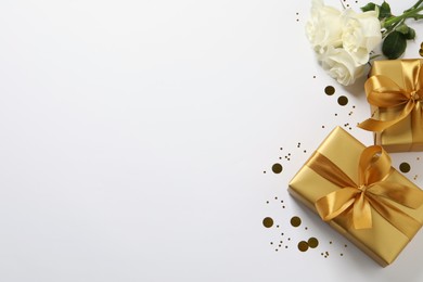 Photo of Beautiful golden gift boxes, flower and confetti on white background, flat lay. Space for text