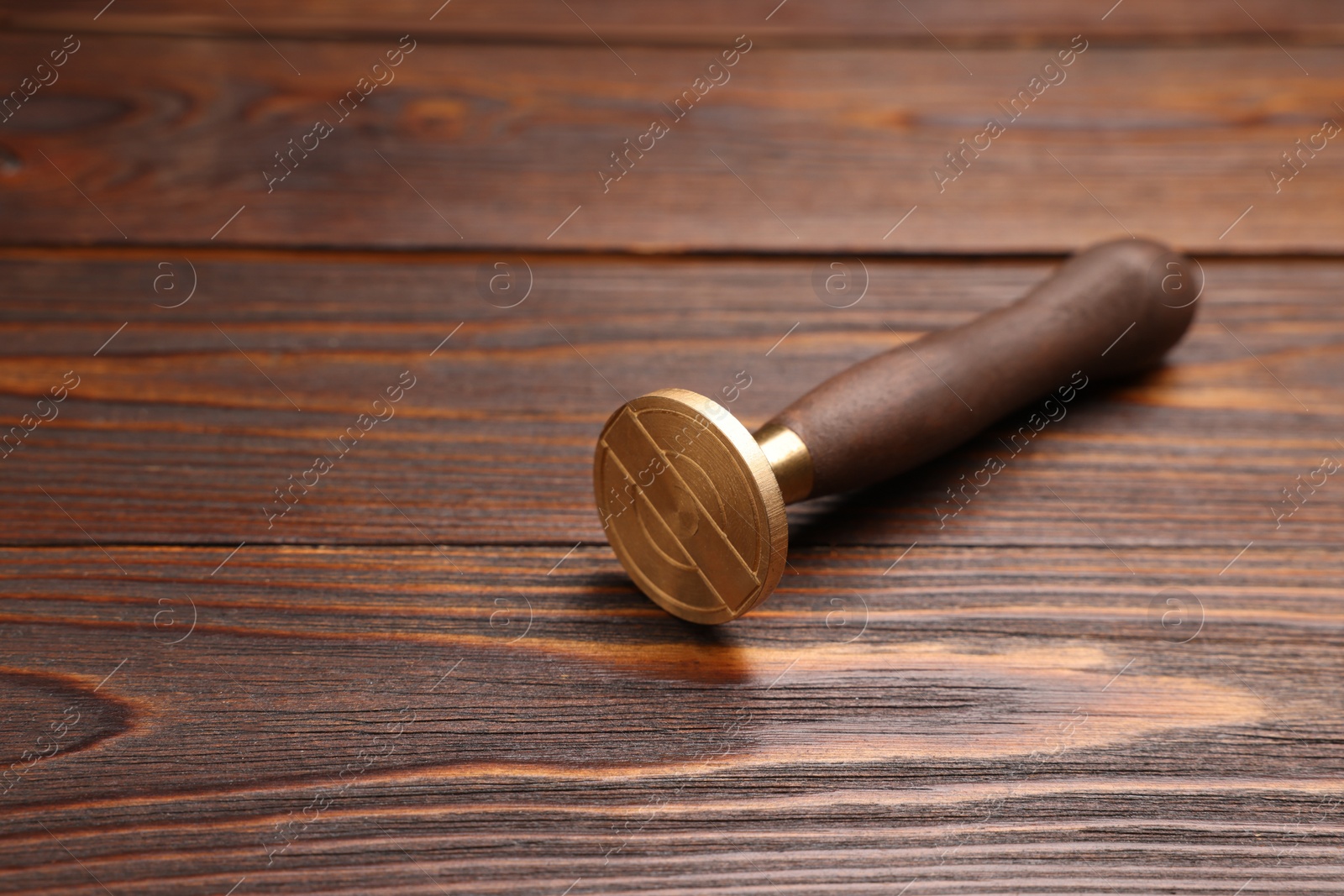 Photo of One stamp tool on wooden table, closeup. Space for text