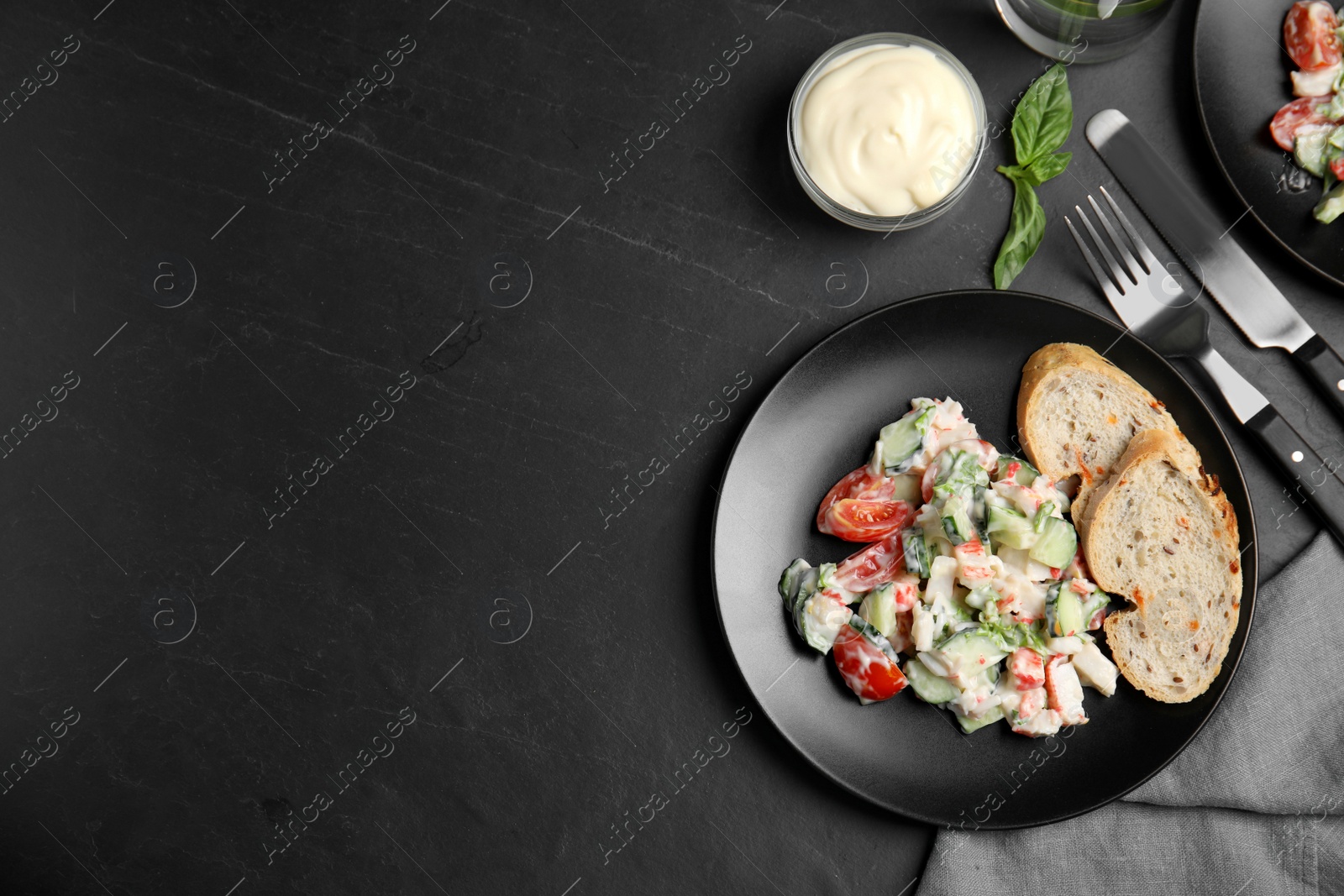 Photo of Delicious salad with mayonnaise served on black table, flat lay. Space for text