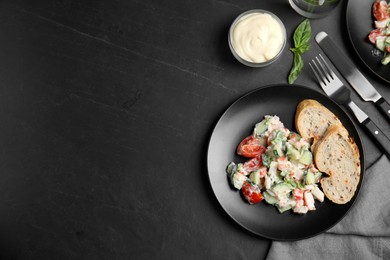 Delicious salad with mayonnaise served on black table, flat lay. Space for text