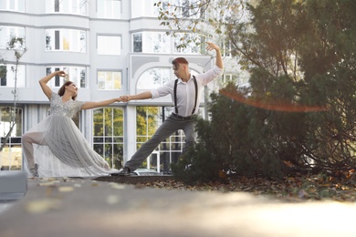 Photo of Beautiful young couple practicing dance moves outdoors