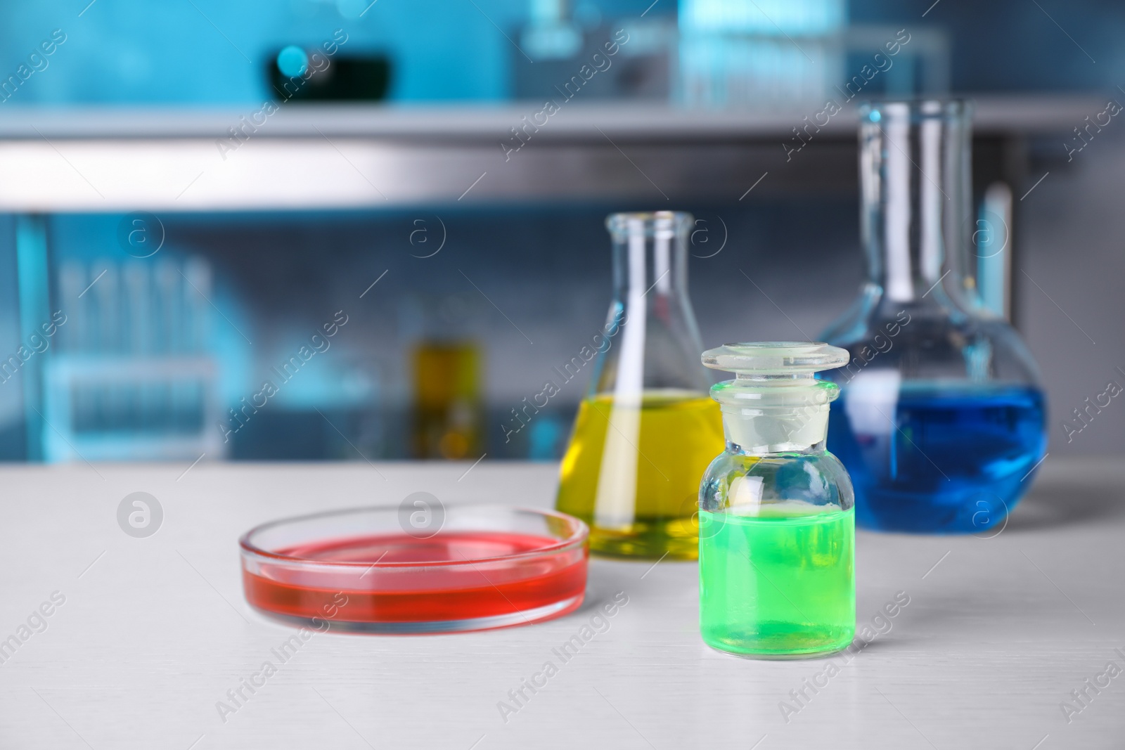 Photo of Different glassware with samples on table in chemistry laboratory