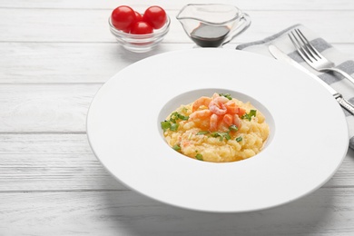 Plate with tasty shrimps and grits on table