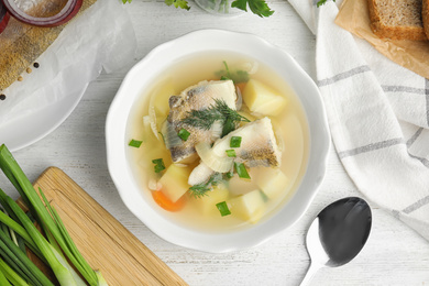 Photo of Delicious fish soup served on white wooden table, flat lay
