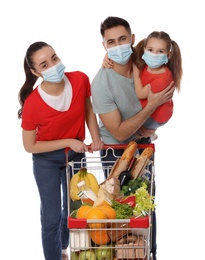 Family with protective masks and shopping cart full of groceries on white background