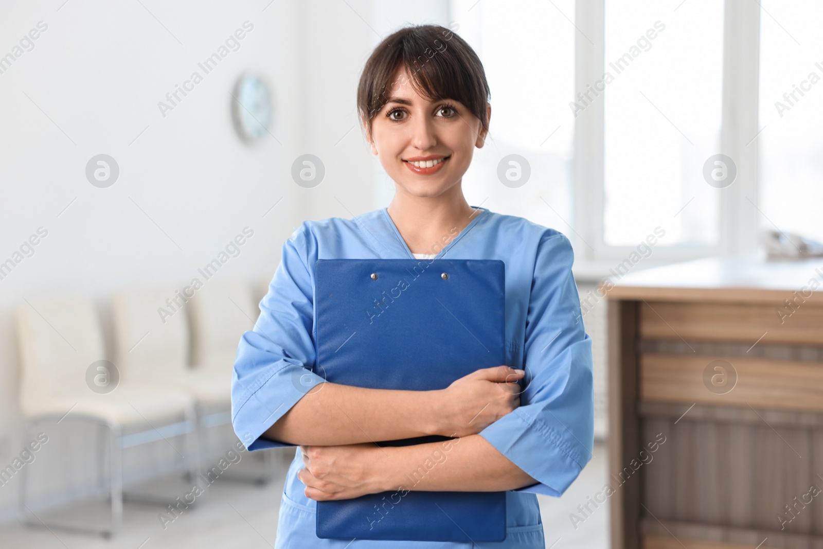 Photo of Portrait of smiling medical assistant with clipboard in hospital